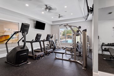 Small fitness center with multiple pieces of exercise equipment, a weigh station and a window overlooking the pool