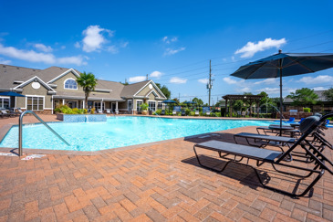 An exquisitely large pool surrounded by loungers near the clubhouse at Waterford Place at Riata Ranch in Cypress, TX. 