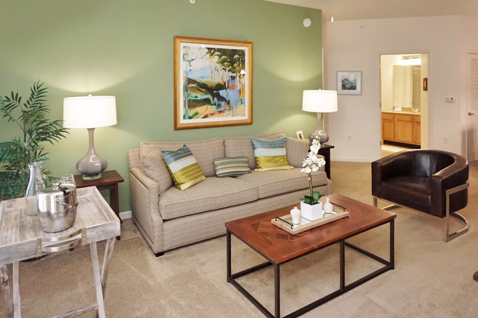 Cozy living space adorned with soft carpeting, offering convenient access to a nearby bathroom and hallway.