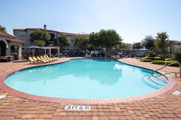 A resort-style pool with loungers for residents to enjoy at The Pointe at Vista Ridge. 