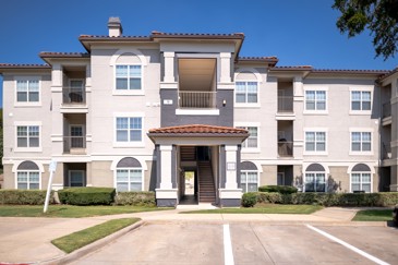 The exterior of The Pointe at Vista Ridge apartments with a parking lot out front at The Pointe at Vista Ridge.