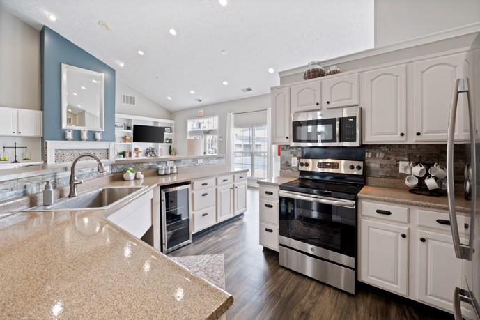 Spacious community kitchen featuring modern appliances, ample cabinets, and a functional sink.