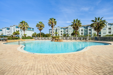 A serene and inviting poolside area at The Enclave at Tranquility Lake in Riverview, FL, featuring lush greenery.