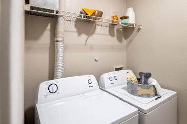 The laundry room with a washer and dryer in an apartment at The Pointe at Vista Ridge.