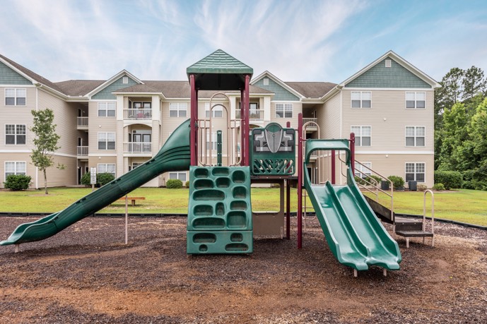 Outdoor community playground with slides at Brunswick Point apartments in Wilmington, NC