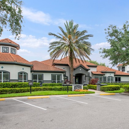 Leasing office at Lucerne in Brandon, FL: Conveniently situated near parking with lush trees and bushes in the vicinity.