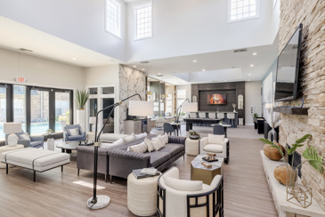A huge community clubhouse with skylights, lounge areas, and TV at The Chelsea.