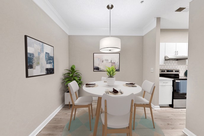 An inviting apartment showcasing a round dining table and four chairs adjacent to the kitchen at The Residences on McGinnis Ferry, offering residents a cozy and intimate dining area for shared meals and gatherings.