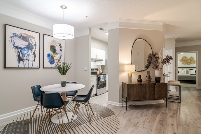 An inviting apartment showcasing a round dining table and four chairs adjacent to the kitchen at The Residences on McGinnis Ferry, offering residents a cozy and intimate dining area for shared meals and gatherings.