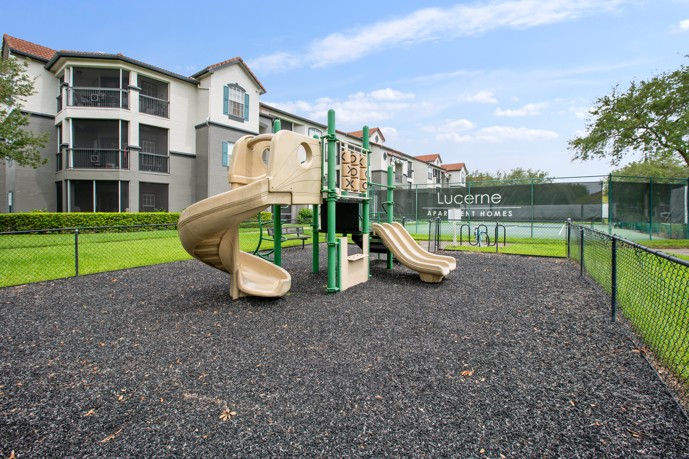 Playground situated nearby a tennis court at Lucerne Apartment Homes.