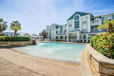 The Enclave at Tranquility Lake in Riverview, FL, showcasing the pool area surrounded by apartment buildings and lush greenery.