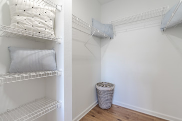 A walk-in closet at The Enclave at Tranquility Lake in Riverview, FL, showcasing shelves, hanging space, and organized storage.