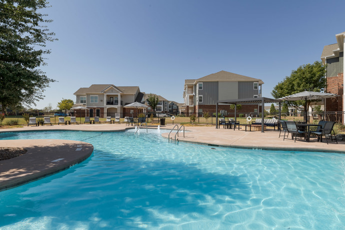 The breathtaking resort-style pool at The Shores, surrounded by the elegant architecture of the apartments and the clubhouse, providing residents with a luxurious outdoor retreat for relaxation and recreation.
