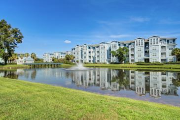 Scenic pond at The Enclave at Tranquility Lake surrounded by lush greenery and featuring a tranquil water surface reflecting the natural surroundings.