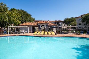 The clubhouse pool with pergolas and loungers at The Pointe at Vista Ridge. 