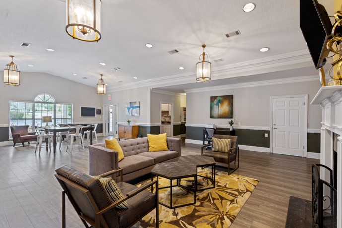 An expansive clubhouse at Spring Hill in Nashville, Tennessee, featuring comfortable seating arrangements and flooded with natural light through large windows, providing residents with a welcoming space for socializing and relaxation.