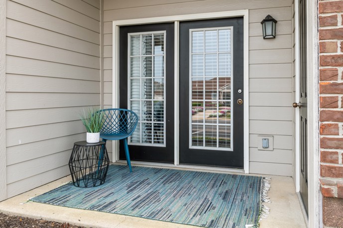 An inviting patio adorned with double doors and a charming lamp fixture.