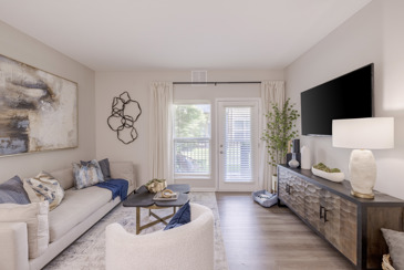 The Chelsea apartment living room with furnishings and entrance to an outdoor space in the vicinity.