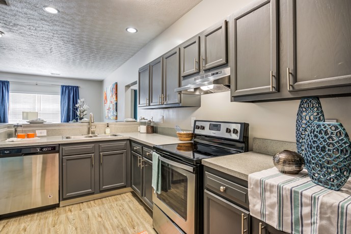Experience a modern apartment kitchen at The Commons at Canal Winchester, complete with dark wood cabinets, sleek granite countertops, and high-quality stainless steel appliances.