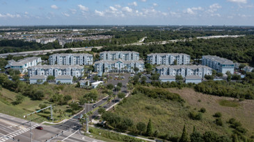 Aerial view of The Enclave at Tranquility Lake in Riverview, FL, featuring lush green landscaping.