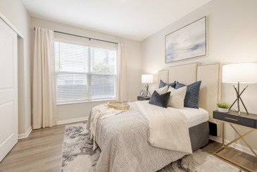 A queen bed with two side tables, large rug, and a large window at The Chelsea.