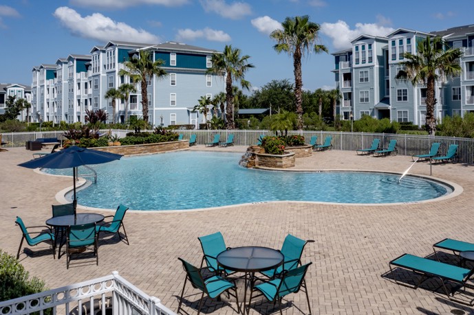 The expansive resort-style pool situated in front of the apartments at The Enclave at Tranquility Lake, providing residents with a luxurious outdoor space for relaxation and recreation.