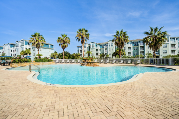 The expansive resort-style pool situated in front of the apartments at The Enclave at Tranquility Lake, providing residents with a luxurious outdoor space for relaxation and recreation.