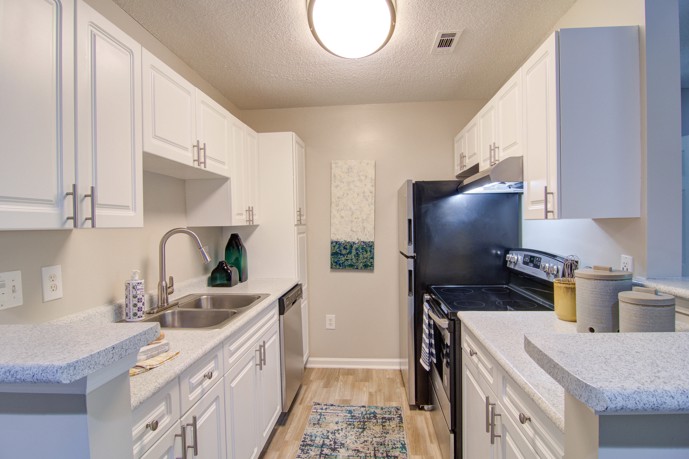 Well-appointed kitchen boasting stainless steel appliances, a double-basin sink, and hardwood-style flooring.