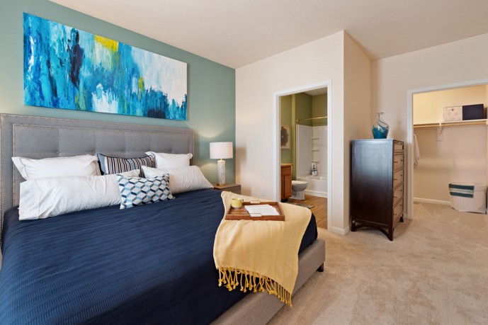 A cozy bedroom with plush carpeting, a spacious walk-in closet, and a private bathroom.