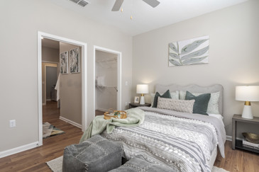 A bedroom at The Enclave at Tranquility Lake in Riverview, FL, showcasing modern furnishings, soft lighting, and a tranquil ambiance.