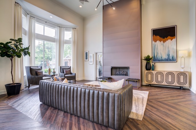 The clubhouse at Thornhill, offering a cozy ambiance with inviting lounge seating, a warm fireplace, and expansive windows allowing natural light to fill the space.