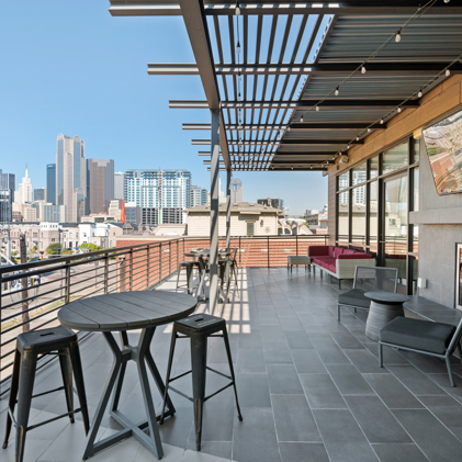 A captivating aerial perspective showcasing Eleven10 at Farmers Market, highlighting the apartment building, the sparkling pool area, and the iconic downtown Dallas skyline.