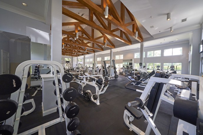 Fitness center at Sugar Mill apartments with weights and machines in a spacious room.