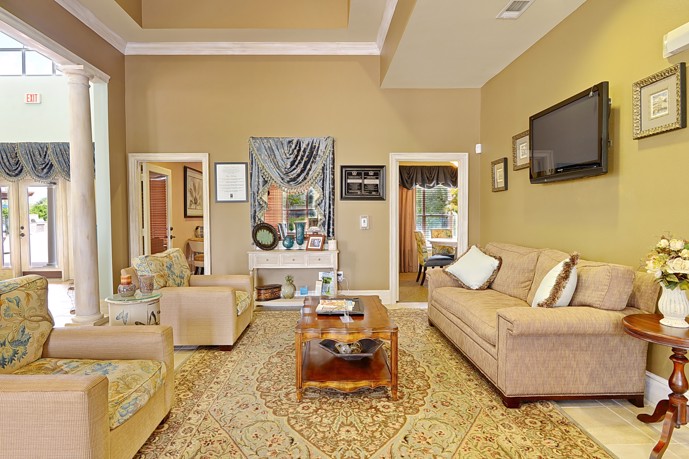 Waterford Place at Riata Ranch clubhouse boasts high ceilings, comfortable plush couches, and a large TV, creating a luxurious and cozy ambiance for its residents