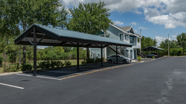 Carport and parking at The Enclave at Tranquility Lake in Riverview, FL, featuring well-marked parking spaces and surrounded by landscaped areas.