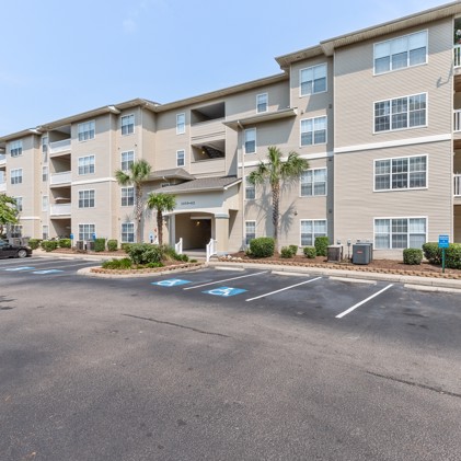Parking lot view of the exterior of the apartments at Cherry Grove Commons in North Myrtle Beach, SC