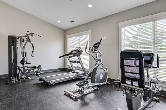 A fitness center with floor-to-ceiling windows, offering a bright and motivating atmosphere for your workout at The Commons at Canal Winchester.