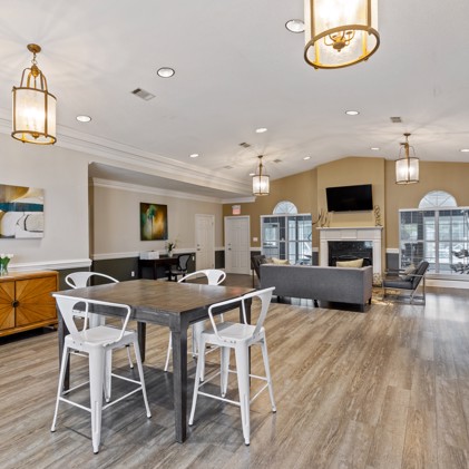 The clubhouse at Spring Hill apartments, in Nashville, TN,  equipped with comfortable seating, a crackling fireplace, and a television, providing residents with a cozy and inviting space for socializing and entertainment.