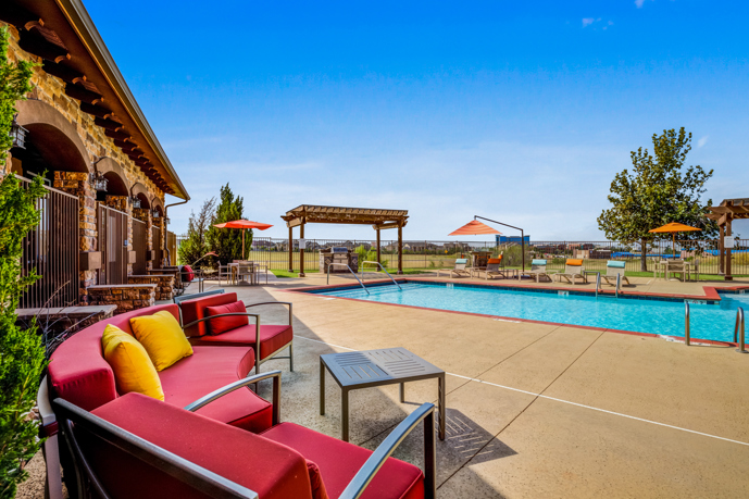A serene view of the pool area with firepit and grilling station