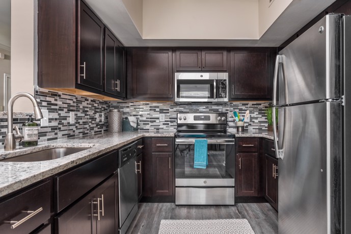 A modern kitchen equipped with stainless steel appliances, granite countertops, and ample cabinet space, creating a functional and stylish cooking area for residents to prepare meals and gather with family and friends.