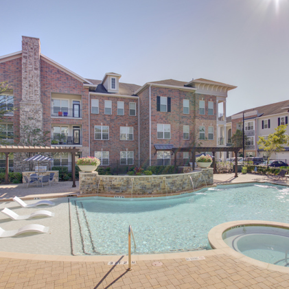 Exterior perspective of Heritage Grand at Sienna's three-story apartment building situated conveniently close to resident parking.