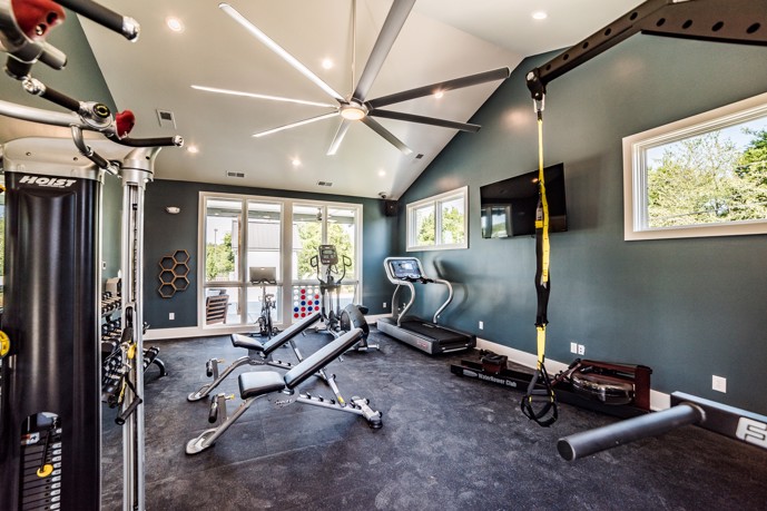 The modern fitness center, featuring dark blue walls, glass doors, and dark flooring at Virtuoso apartments in Huntsville, AL.