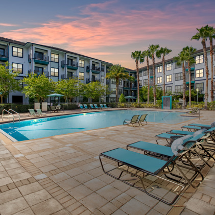 Captivating aerial vista showcasing the swimming pool and sun-drenched sundeck, adorned with inviting lounge chairs amidst the apartment enclave at Millenia 700.