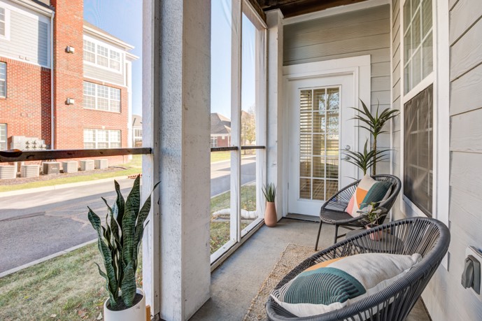 Bayview Club apartment enclosed glass patio with two chairs overlooking another building
