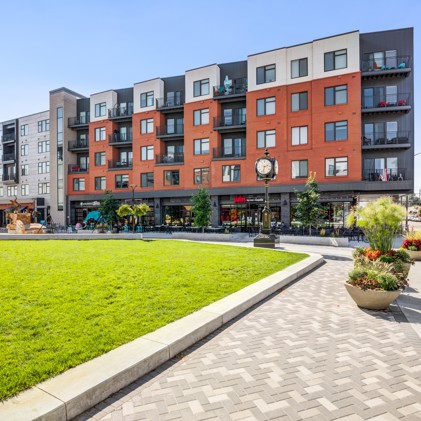 An exterior view of Patina Flats at the Foundry, showcasing the modern architecture, landscaped grounds, and inviting communal spaces