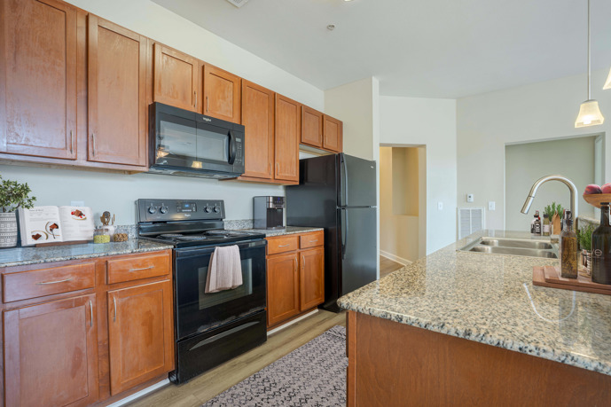 Kitchen featuring wood cabinets, granite countertops, and a double sink.