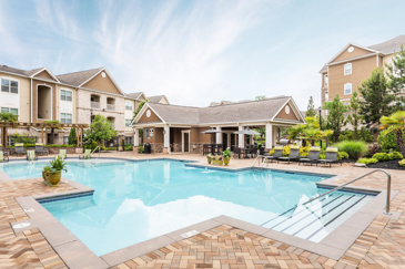 Waterstone at Big Creek features a spacious pergola adjacent to the pool, offering ample seating underneath for residents to relax and enjoy the surroundings.