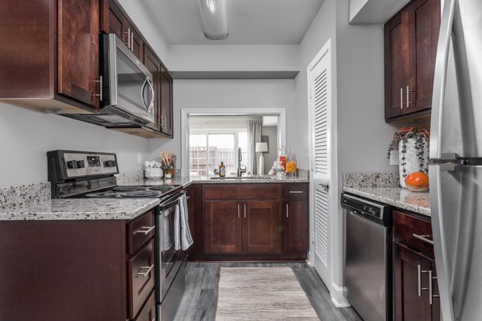 Well-appointed kitchen equipped with granite countertops, stainless steel appliances, and stylish hardwood-style flooring.