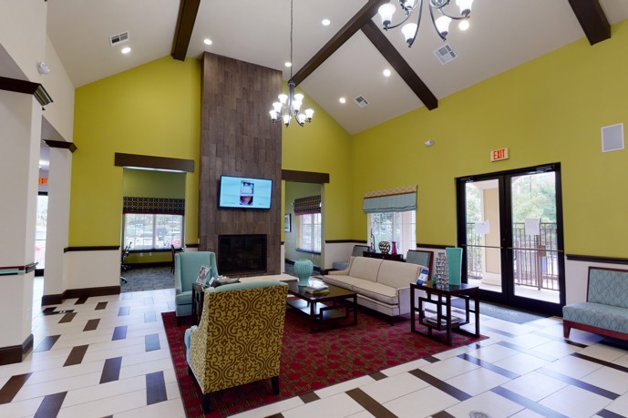 Step into a contemporary clubhouse, adorned with a cozy fireplace and comfortable seating.