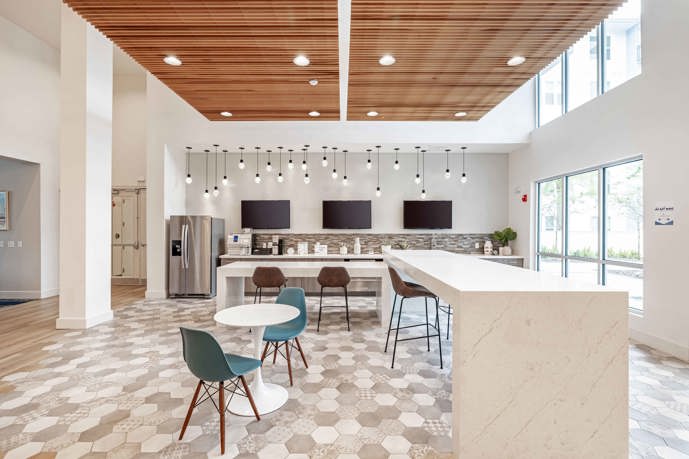 Clubhouse boasting vaulted ceilings, a TV, expansive windows, and dual seating areas.